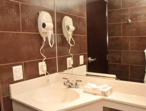 埃斯特利Hotel Hex Estelí的浴室配有盥洗盆、镜子和吹风机