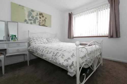 考文垂Yewdale House的一间卧室配有一张床、一张书桌和一个窗户。