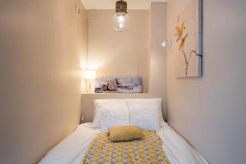 里昂Appartement Lyon Gerland - Enjoy in Lyon的小卧室配有带枕头的床