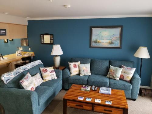 新港兰丁纽波特公寓酒店的客厅配有2张蓝色的沙发和1张桌子