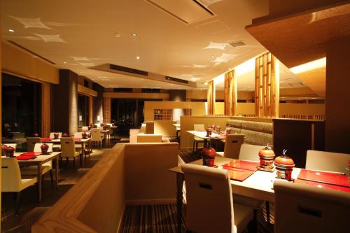南淡路市广场淡路岛酒店的一间带桌子和白色椅子及桌子的餐厅