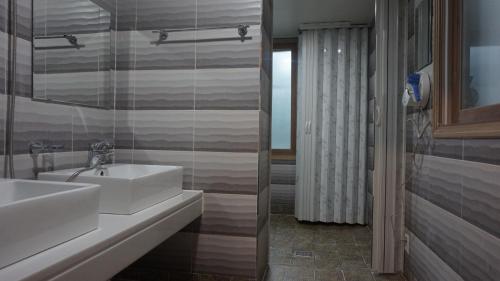 春川Sh Guesthouse的浴室设有白色水槽和镜子