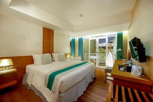 库塔库塔基岩酒店的一间卧室设有一张大床和一个窗户。