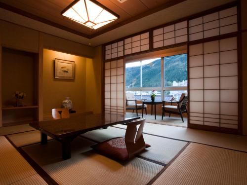 下吕市富岳下吕温泉酒店的日式客房配有桌子和窗户。