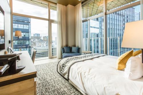 东京银座名铁穆瑟酒店(Hotel Musse Ginza Meitetsu)的一间卧室设有一张床和一个大窗户