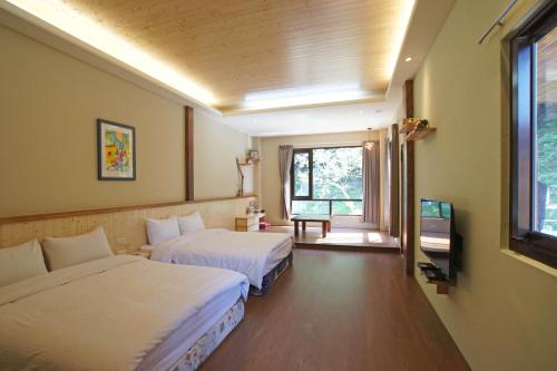 南庄乡天堂鸟民宿的酒店客房设有两张床和窗户。