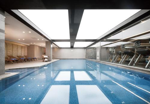 首尔首尔中心辉盛坊国际公寓的大楼内带椅子的游泳池