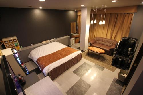 Higashine辛德巴德情趣酒店山形店的一间卧室配有一张床、一把椅子和一张沙发