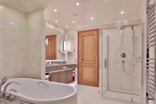 卡罗维发利Retro Riverside Wellness Resort的设有带浴缸和淋浴的浴室。