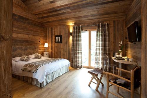 Marigny-Saint-Marcel布兰科酒店的一间卧室配有一张床、一张书桌和一台电视
