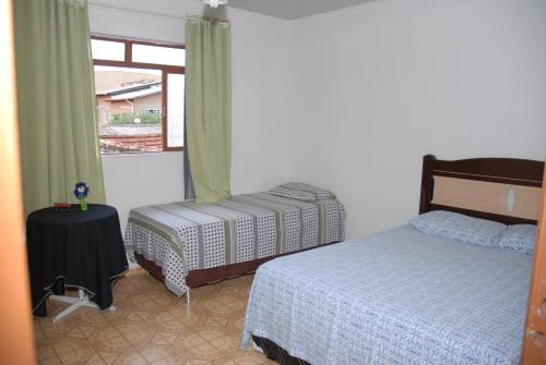 戈亚尼亚Pousada Ana Poipa的一间卧室设有两张床和窗户。