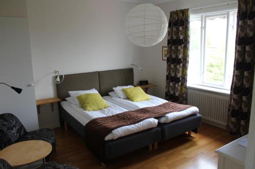 博里霍尔姆英格丽别墅酒店的一间卧室配有一张带黄色枕头的床。