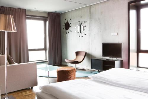 斯塔万格康福特茵酒店的一间卧室配有一张床、一把椅子和电视