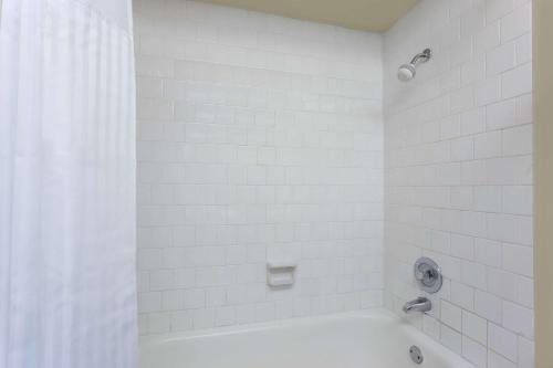 贝灵厄姆Days Inn By Wyndham Bellingham WA的白色的浴室设有浴缸和淋浴。