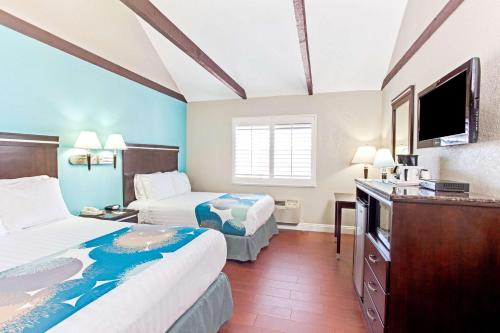 长滩Cabana Inn & Suites的酒店客房设有两张床和一台平面电视。