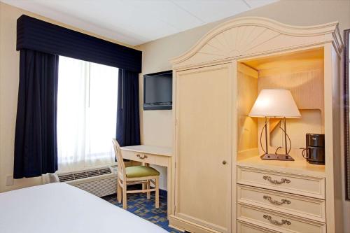 东温莎Windsor Hotel的配有一张床和一张书桌的酒店客房