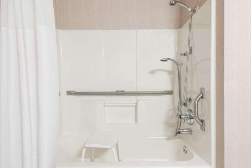 卡本代尔Days Inn by Wyndham Carbondale的带淋浴和白色浴缸的浴室