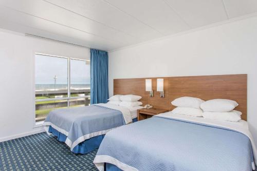 斩魔山Mariner Inn And Suites的酒店客房设有两张床和窗户。