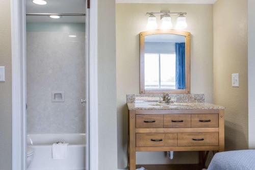 斩魔山Mariner Inn And Suites的浴室配有盥洗盆、镜子和浴缸
