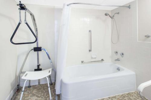 迪比克迪比克戴斯酒店的带淋浴和白色浴缸的白色浴室