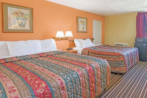 亨里埃塔罗切斯特戴斯酒店的橙色墙壁的酒店客房内的两张床