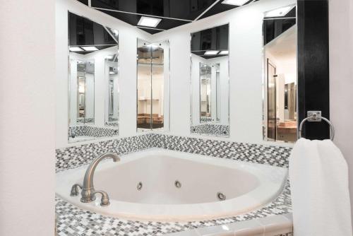 圣克莱尔斯维尔圣克莱斯维尔戴斯酒店的带浴缸和几面镜子的浴室