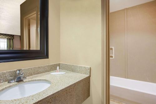 Centerville维尔中央戴斯酒店的浴室配有盥洗盆、镜子和浴缸