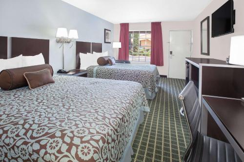 达拉斯Days Inn by Wyndham Market Center Dallas Love Field的酒店客房设有两张床和一台平面电视。