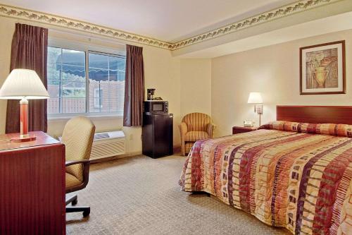 莱克伍德克利夫兰莱克伍德戴斯酒店的酒店客房,配有一张床、一张桌子和椅子