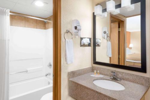 埃姆斯埃姆斯戴斯酒店的一间带水槽、浴缸和镜子的浴室