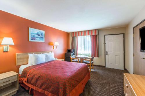 土桑图森机场戴斯汽车旅馆的酒店客房设有一张大床和一张书桌。