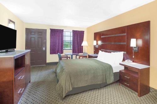 费耶特维尔费耶特维尔戴斯酒店的配有一张床和一台平面电视的酒店客房