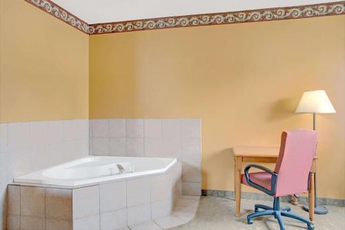 莱赫戴斯酒店 - 莱赫的带浴缸、椅子和桌子的浴室