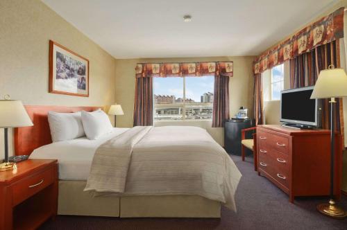 里士满温哥华机场戴斯酒店的一间设有大床和窗户的酒店客房