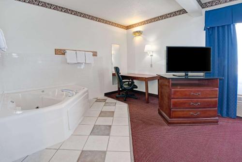 拉勒米拉勒米戴斯酒店的带浴缸、书桌和电视的浴室