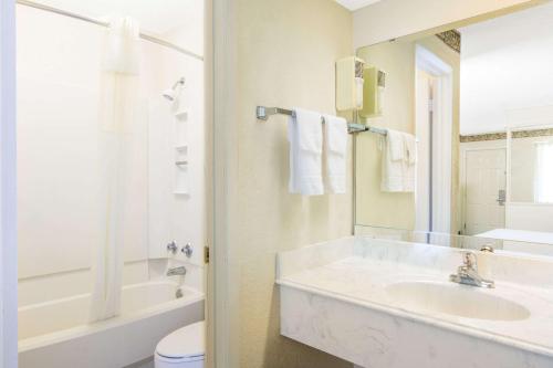 马绍尔马歇尔戴斯套房酒店的带浴缸、盥洗盆和卫生间的浴室