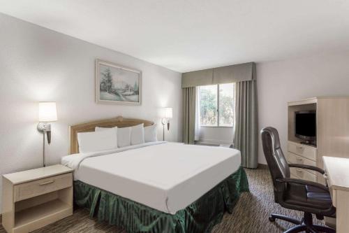 皮奥里亚皮奥里亚格伦代尔戴斯酒店的酒店客房设有一张大床和一张书桌。