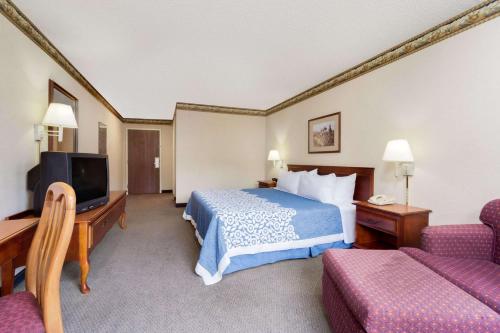 West LibertyMagnuson Hotel West Liberty的一间酒店客房,配有一张床和一台电视