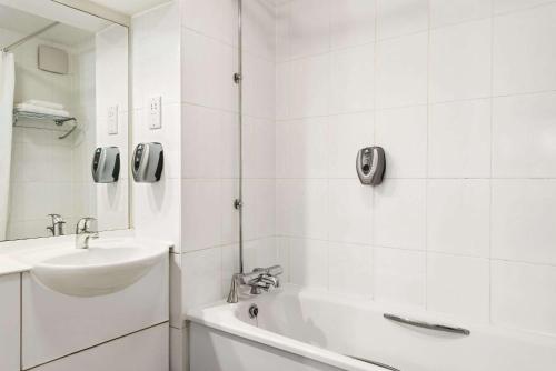 肯德尔戴斯肯达尔酒店 - 肯灵顿湖的白色的浴室设有水槽、浴缸和淋浴。