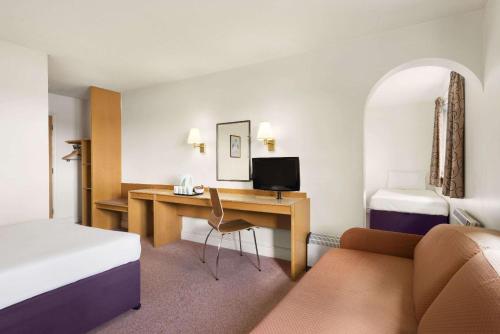 肯德尔戴斯肯达尔酒店 - 肯灵顿湖的酒店客房配有书桌和床。