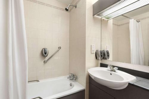 斯塔福德戴斯斯塔福德酒店的一间带水槽、浴缸和镜子的浴室