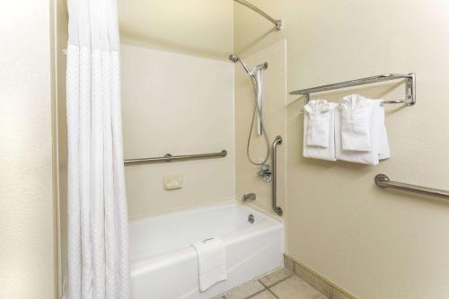 科罗拉多斯普林斯科罗拉多斯普林斯机场戴斯汽车旅馆的浴室配有浴缸和淋浴及浴帘