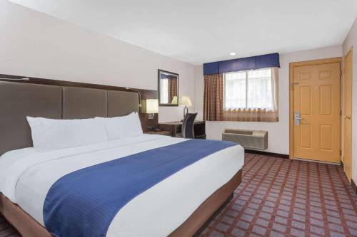 伍德伯里戴斯伍德伯里酒店的酒店客房设有一张大床和一张书桌。