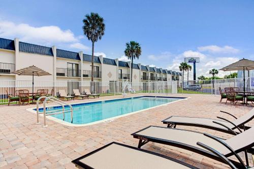 坦帕Days Inn & Suites by Wyndham Tampa - Ybor City的一个带躺椅的游泳池和一间酒店