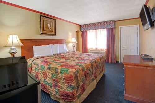 阿尔伯克基阿尔伯克基城区戴斯酒店的酒店客房,配有床和电视