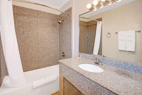 阿尔伯克基阿尔伯克基城区戴斯酒店的一间带水槽、浴缸和镜子的浴室