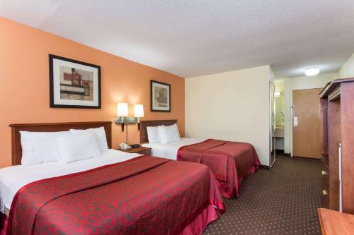 布卢明顿布卢明顿努马戴斯酒店的酒店客房,配有两张带红色床单的床