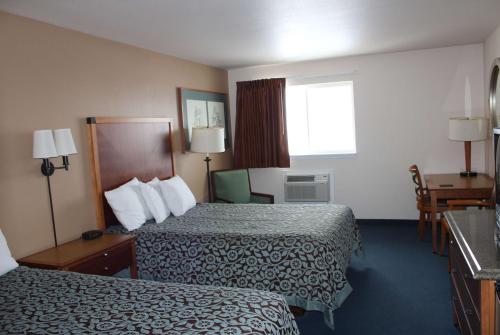 里茨维尔Days Inn by Wyndham Ritzville的酒店客房设有两张床和窗户。