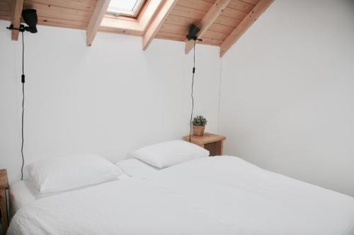 雷讷瑟Bed & Breakfast Zeeland的窗户客房内的一张白色床