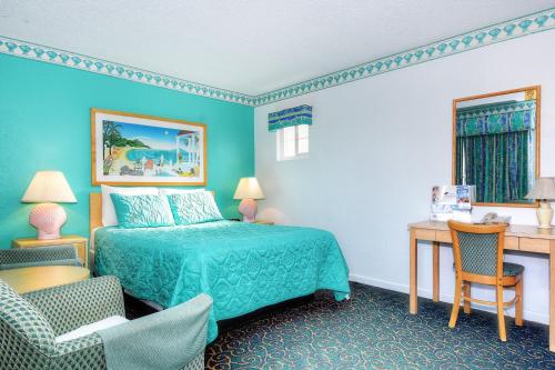 莫罗贝莫洛湾圣德派普尔旅馆的一间卧室配有一张床、一张桌子和一把椅子
